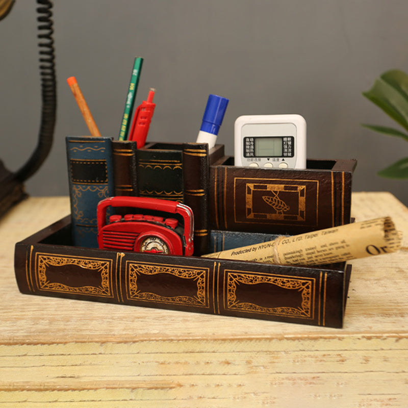 Book-style pen holder tray styled on a desk with a remote control and plant