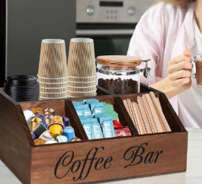 Close-up of a person by a wooden coffee bar organizer filled with cups and coffee pods