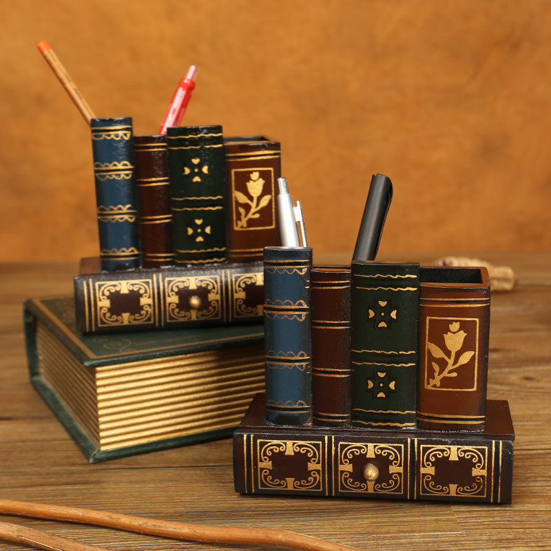 Vintage book stack pen holder styled on a desk with pens and an antique book